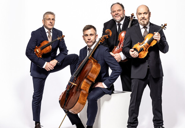 Fyra unga musiker med instrument. Fotografi.