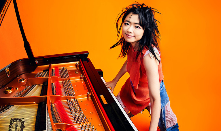 Närbild på ung tjej vid piano. Fotografi.