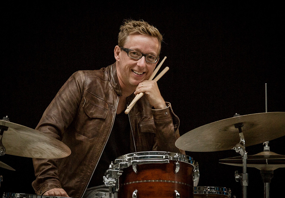 Man som sitter vid ett trumset. Fotografi.