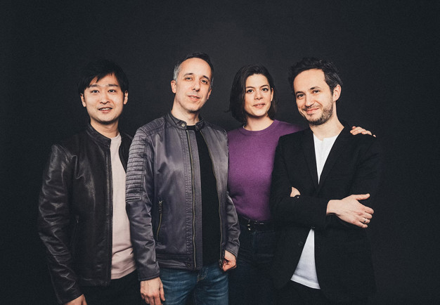 Fyra personer på rad. Fotografi.