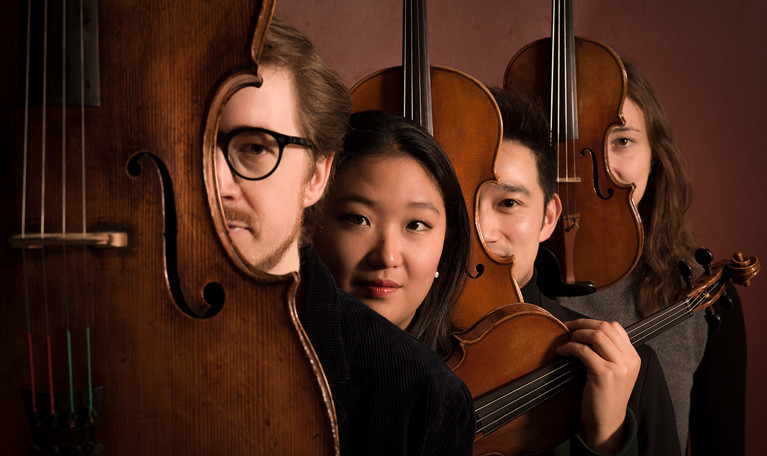 Fyra musiker på rad. Fotografi.