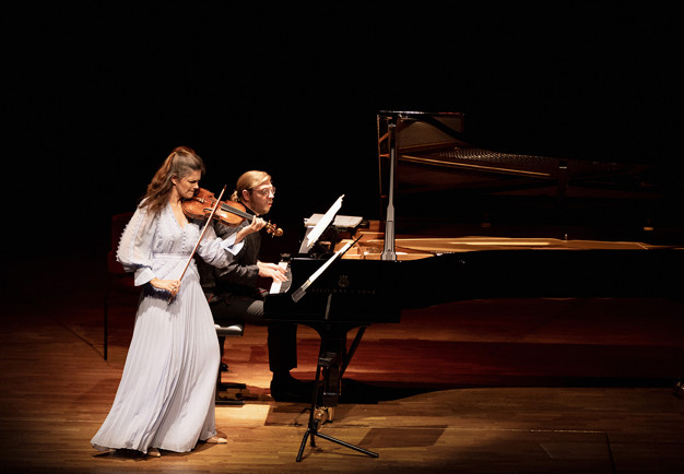 Kvinna som spelar violin och man som spelar piano. Fotografi.
