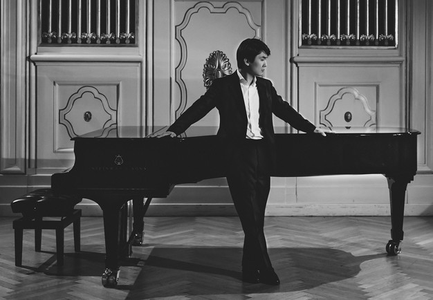 Kvinna som sitter på en stol med en cello. Fotografi