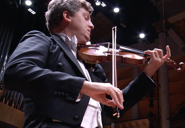 Man som spelar violin. Fotografi