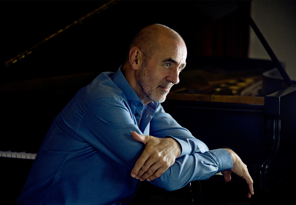 Närbild på man vid piano. Fotografi.